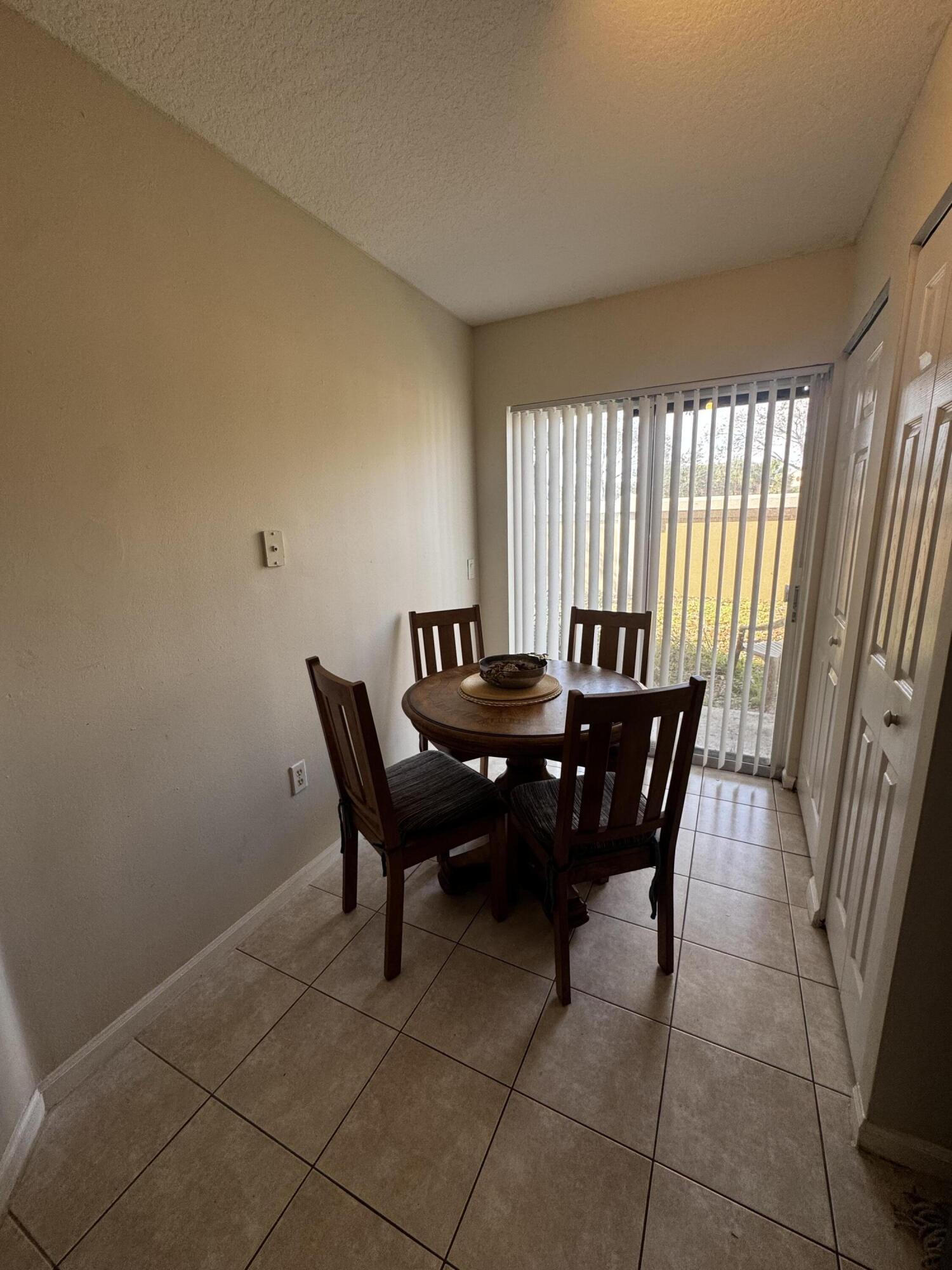 3810 North Jog Road, Unit 105 Royal Palm Beach, FL 33411 - Photo 18 of 26 a view of a dining room with furniture and window
