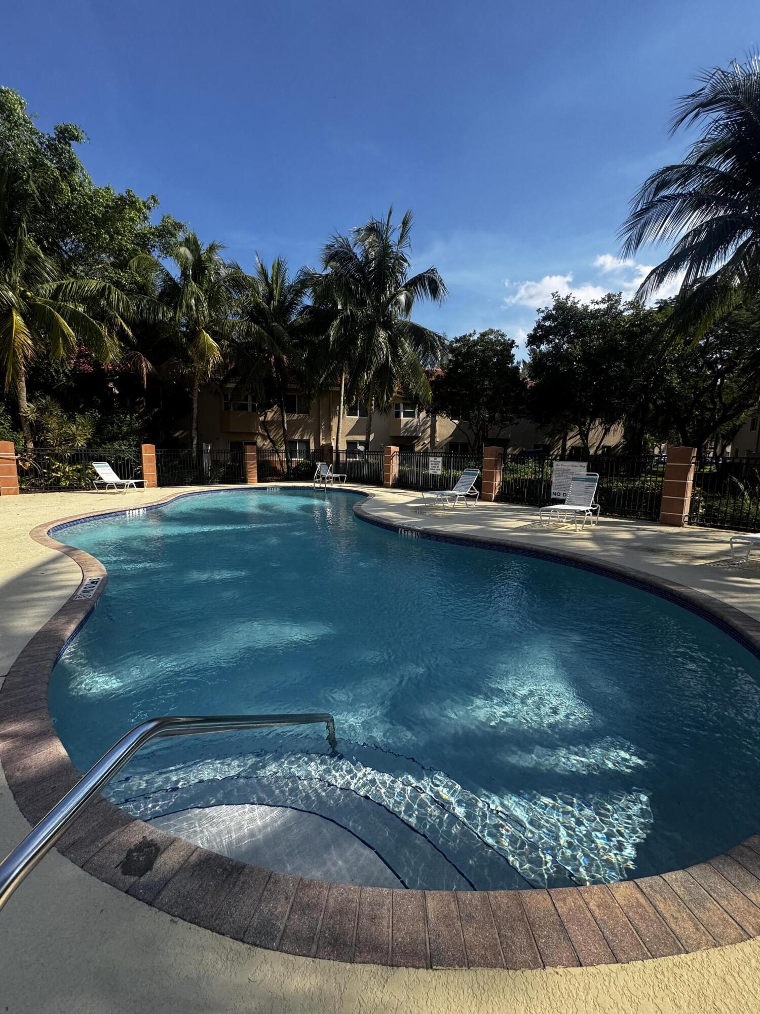 3810 North Jog Road, Unit 105 Royal Palm Beach, FL 33411 - Photo 24 of 26 a view of a swimming pool with an outdoor space and seating area