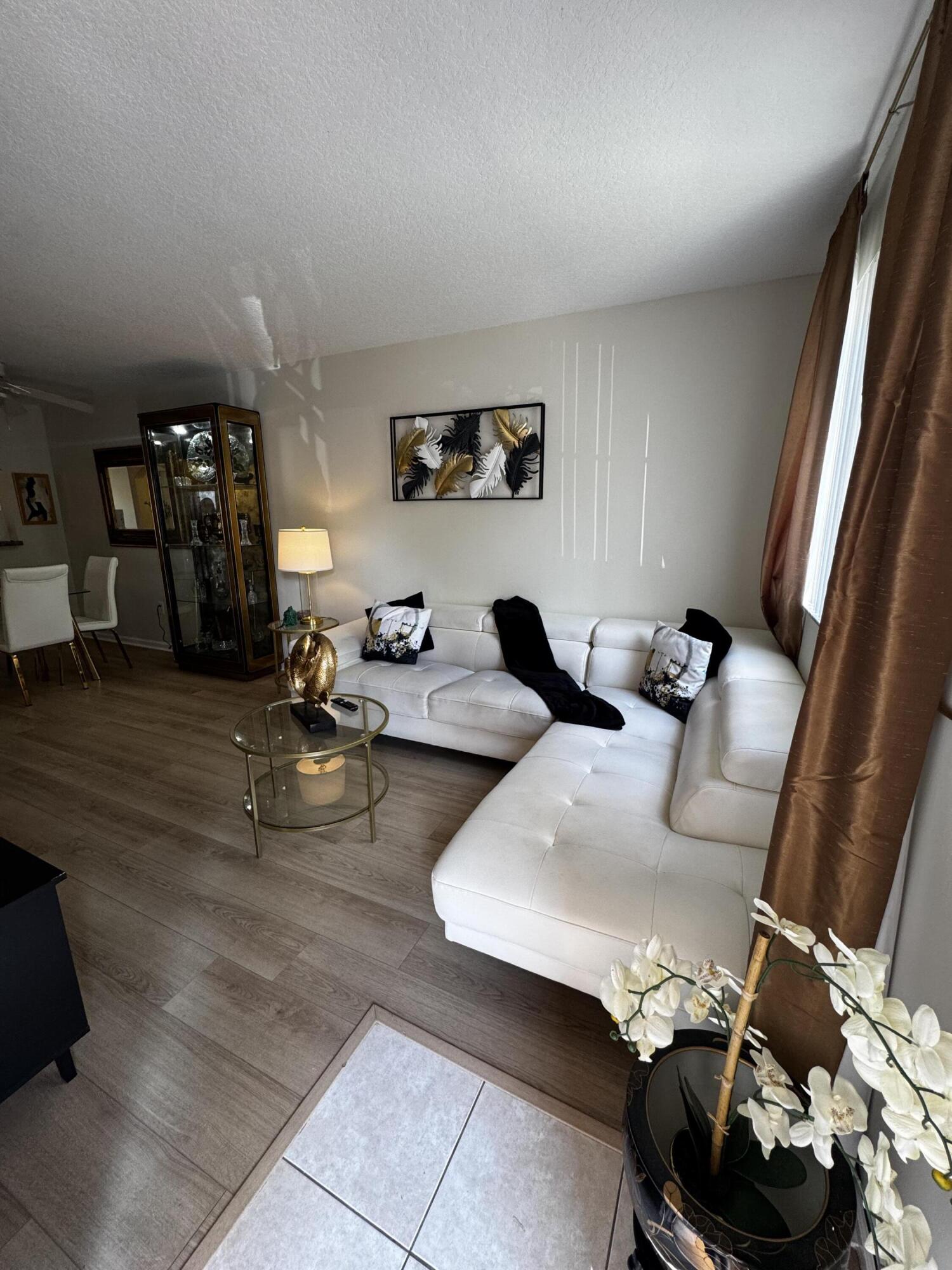 3810 North Jog Road, Unit 105 Royal Palm Beach, FL 33411 - Photo 4 of 26 a living room with furniture and a mirror