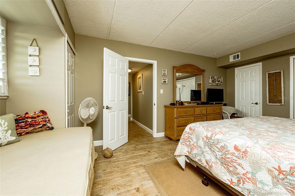 4799 South Atlantic Avenue, Unit 3030 Ponce Inlet, FL 32127 - Photo 13 of 26 a bedroom with a bed and a large mirror on the dresser