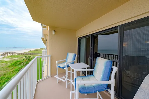 a view of a chairs and table in patio with wooden floor