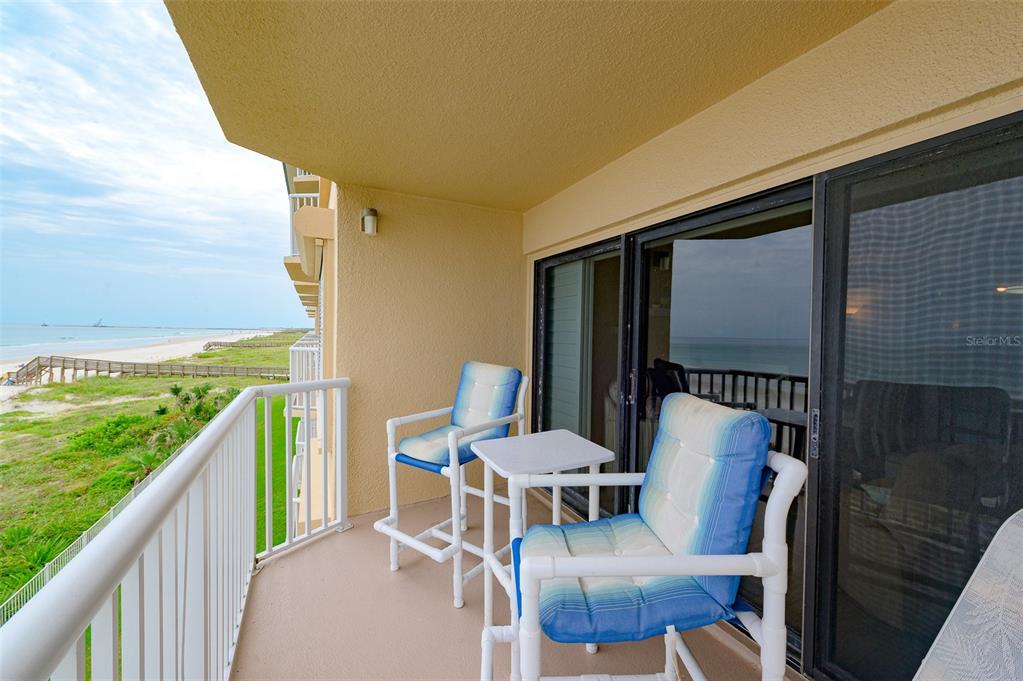 4799 South Atlantic Avenue, Unit 3030 Ponce Inlet, FL 32127 - Photo 18 of 26 a view of a chairs and table in patio with wooden floor