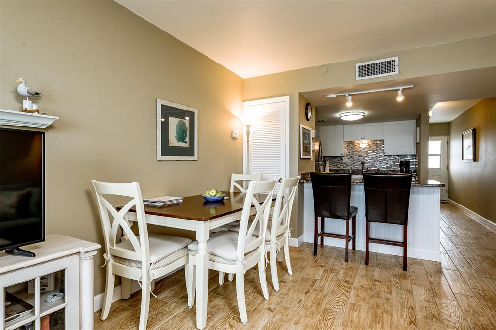 4799 South Atlantic Avenue, Unit 3030 Ponce Inlet, FL 32127 - Photo 8 of 26 a dining room with a table chairs and a kitchen view
