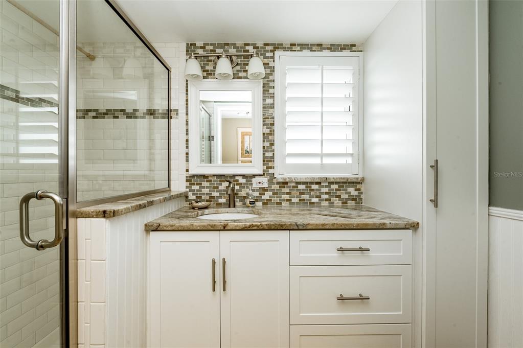 4799 South Atlantic Avenue, Unit 3030 Ponce Inlet, FL 32127 - Photo 10 of 26 a bathroom with a granite countertop sink a mirror and a shower