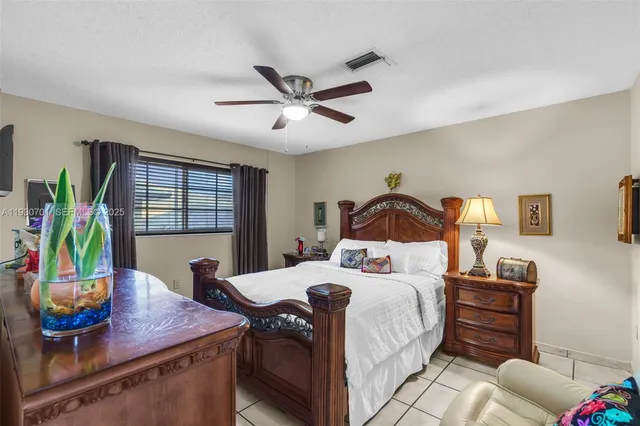 a bedroom with a bed and dresser with wooden floor