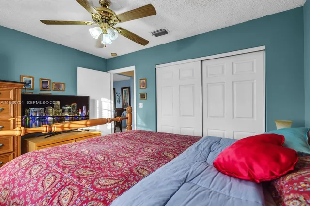 a bedroom with a large bed and a chandelier