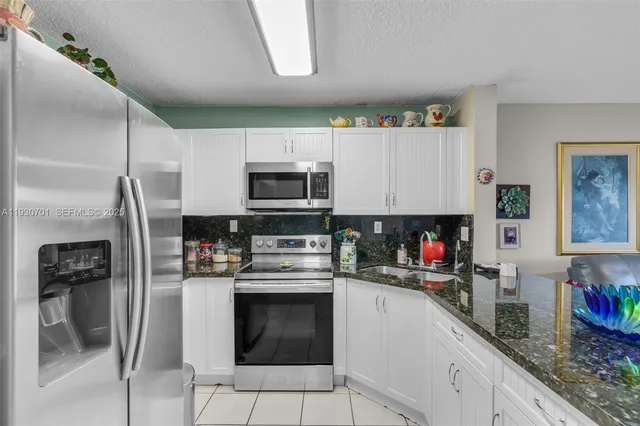 a kitchen with stainless steel appliances a stove microwave and sink