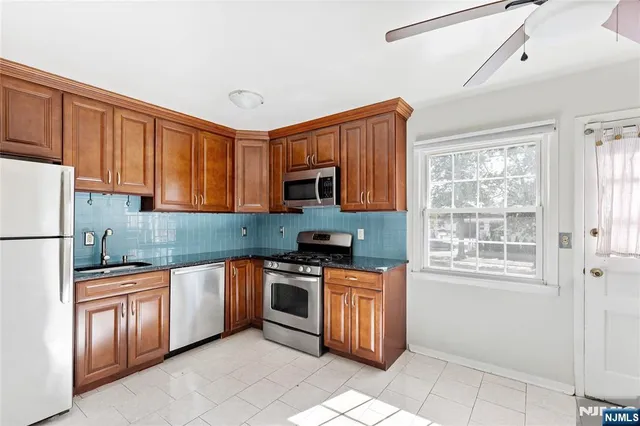 a kitchen with stainless steel appliances granite countertop a stove sink and cabinets