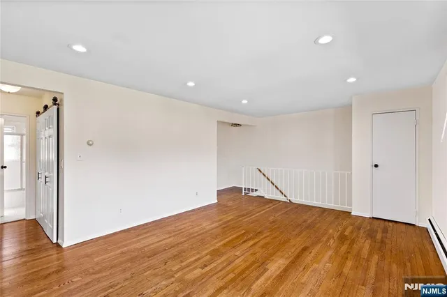 a big room with wooden floor and natural light