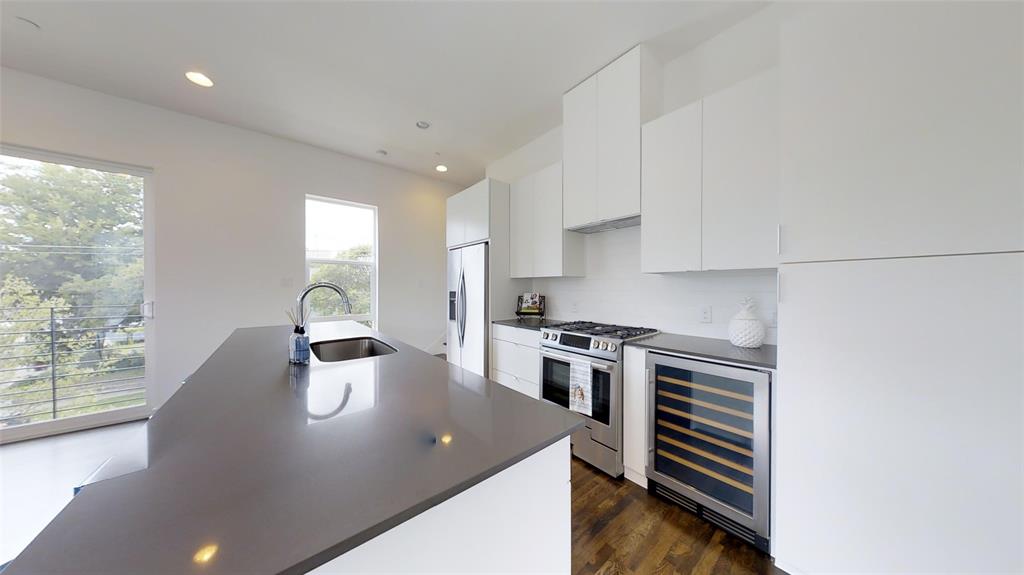4905 Live Oak Street, Unit D Dallas, TX 75206 - Photo 9 of 19 a kitchen with stainless steel appliances a stove a sink a microwave and cabinets