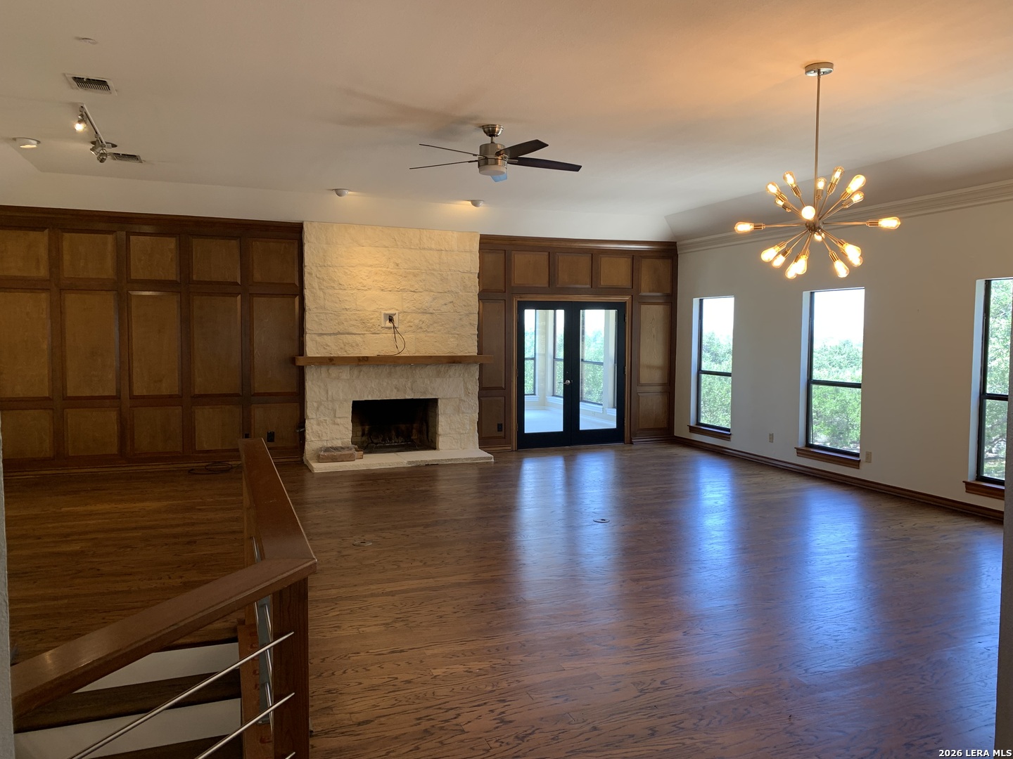 Undisclosed Address Fair Oaks Ranch, TX 78015 - Photo 1 of 12 an empty room with wooden floor fireplace and windows