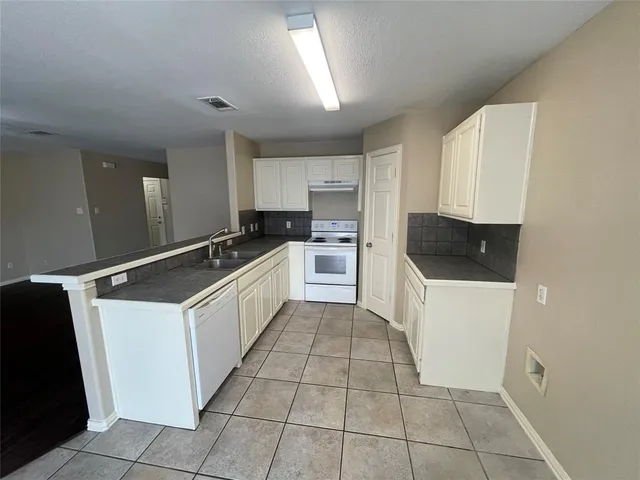a kitchen with a cabinets and white appliances