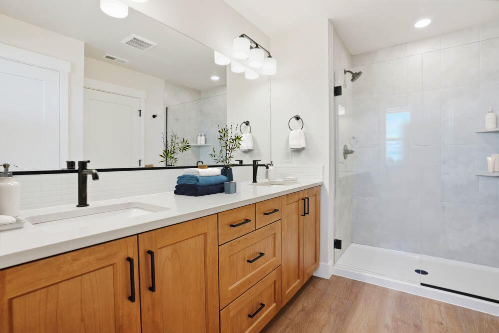 60843 Southeast Epic Place Bend, OR 97702 - Photo 6 of 13 a large bathroom with a double vanity sink a large mirror and shower