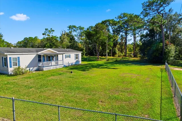 a view of a house with a yard and porch