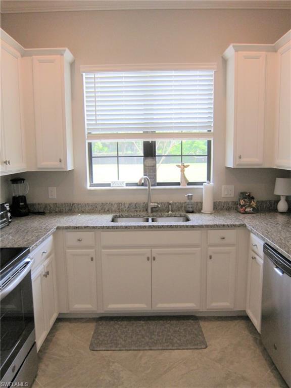 1170 Genovesa Court, Unit 12 Naples, FL 34113 - Photo 12 of 18 a kitchen with granite countertop a sink window and cabinets
