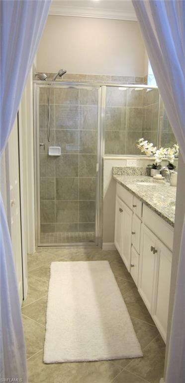 1170 Genovesa Court, Unit 12 Naples, FL 34113 - Photo 8 of 18 a bathroom with a granite countertop sink a mirror and shower