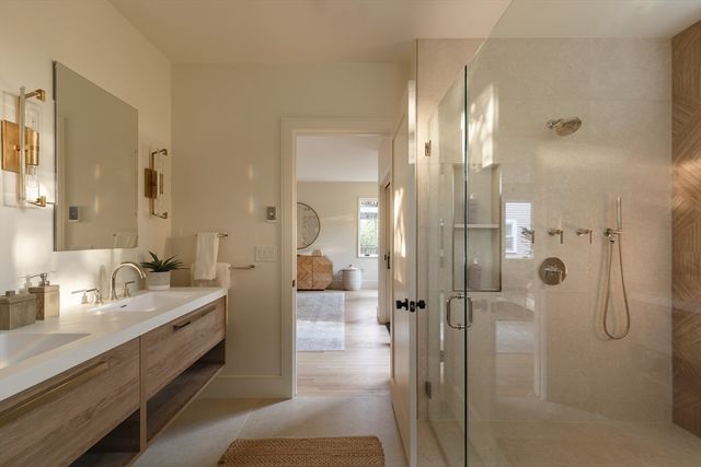 a bathroom with a double vanity sink mirror and shower