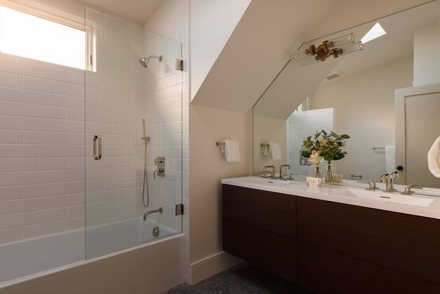 a bathroom with a bathtub double vanity sink and mirror