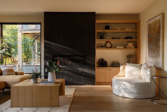 a living room with furniture a flat screen tv and a floor to ceiling window