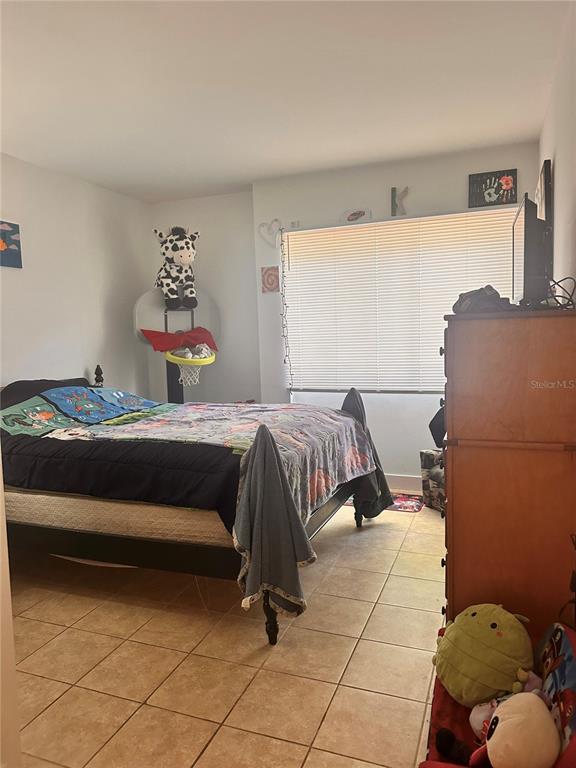 2938 Clark Road, Unit 102 Sarasota, FL 34231 - Photo 12 of 14 a bedroom with a bed and lamp