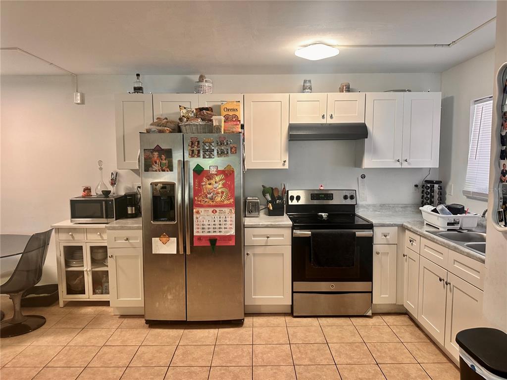 2938 Clark Road, Unit 102 Sarasota, FL 34231 - Photo 4 of 14 a kitchen with stainless steel appliances granite countertop a stove a sink and a refrigerator
