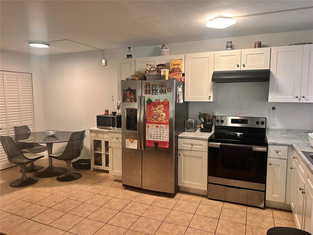 2938 Clark Road, Unit 102 Sarasota, FL 34231 - Photo 5 of 14 a kitchen with stainless steel appliances kitchen island granite countertop a sink and cabinets