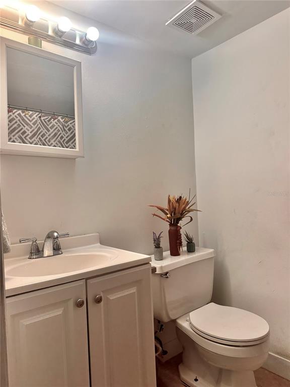 2938 Clark Road, Unit 102 Sarasota, FL 34231 - Photo 8 of 14 a bathroom with a toilet a sink and mirror