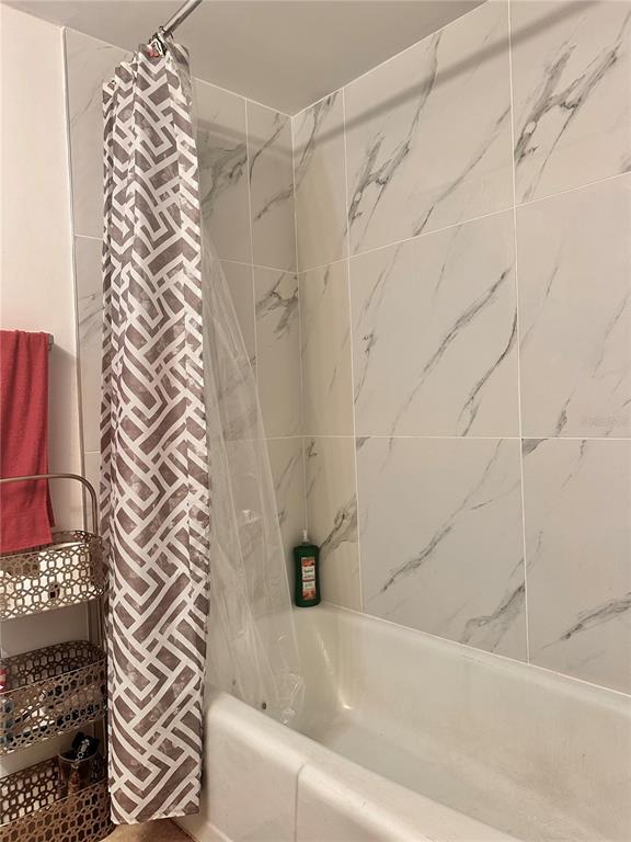 2938 Clark Road, Unit 102 Sarasota, FL 34231 - Photo 9 of 14 a bathroom with a bathtub and shower