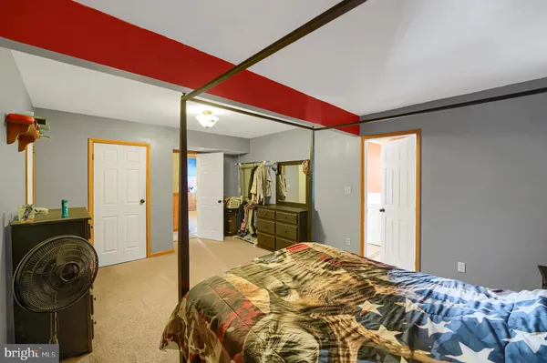 a bedroom with a bed and a mirror on the dresser