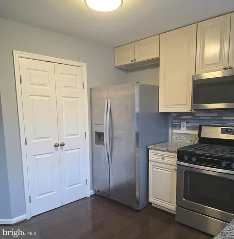 a view of walk in closet with wooden floor