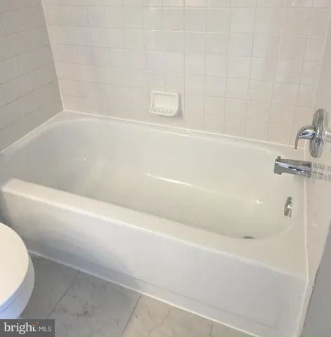 a white toilet and tub sitting next to a bathroom sink