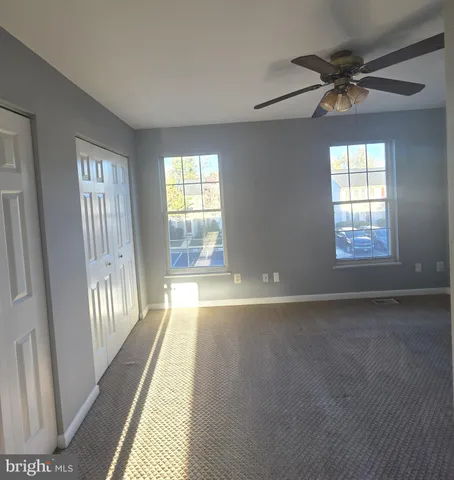a view of a hallway with wooden floor and a bathroom