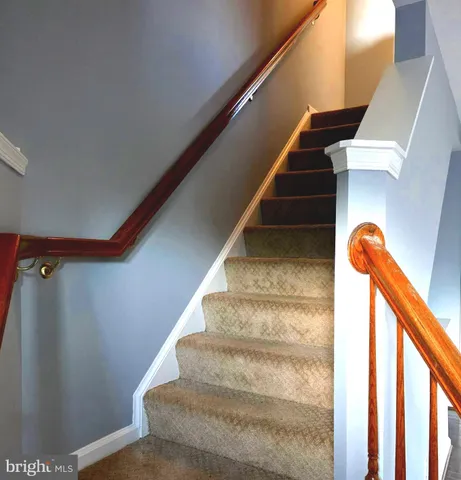 an empty room with wooden floor and windows with curtains