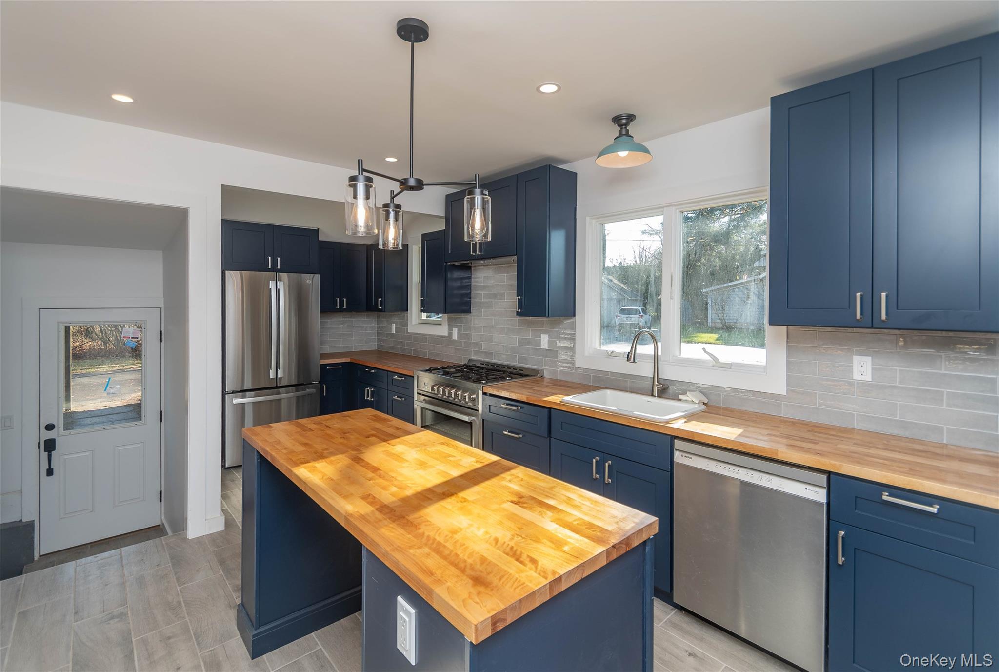 3 Anna Street Kerhonkson, NY 12446 - Photo 5 of 40 Kitchen featuring blue cabinets, stainless steel appliances, butcher block countertops, decorative light fixtures, and recessed lighting