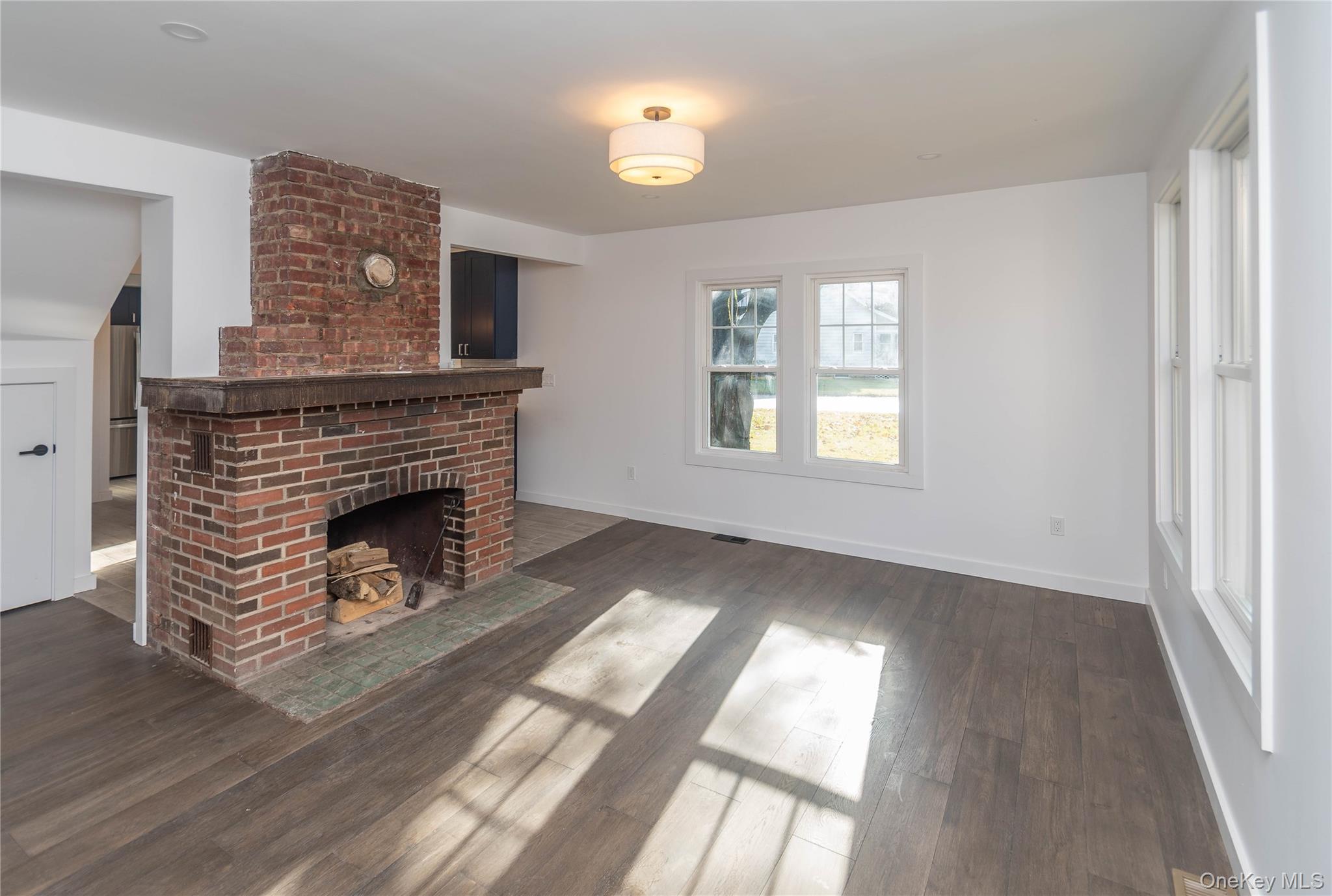 3 Anna Street Kerhonkson, NY 12446 - Photo 10 of 40 Unfurnished living room featuring a brick fireplace and dark wood flooring