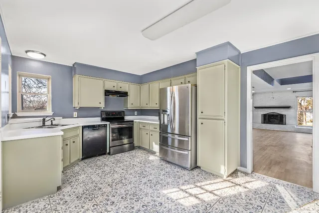 a kitchen with stainless steel appliances granite countertop a refrigerator stove and sink