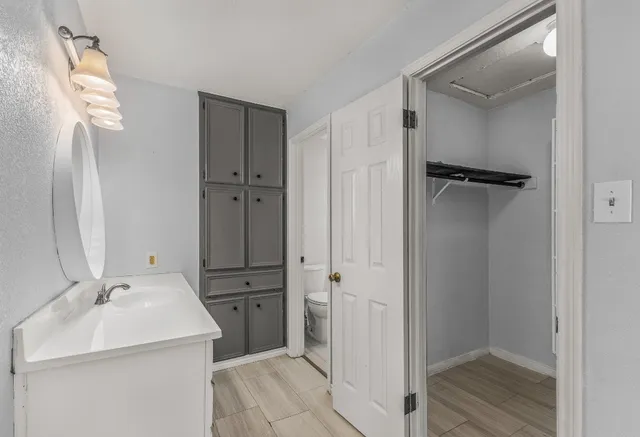 a bathroom with a sink a toilet and a mirror