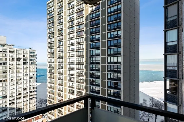 a view of a balcony with a floor to ceiling window next to a tall building