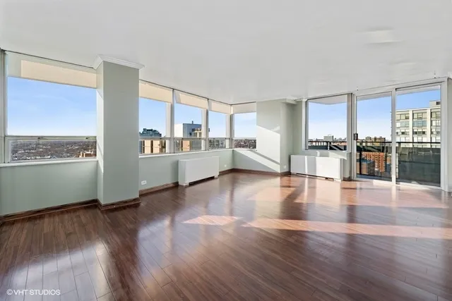 a view of a living room kitchen with a stove top oven and wooden floor