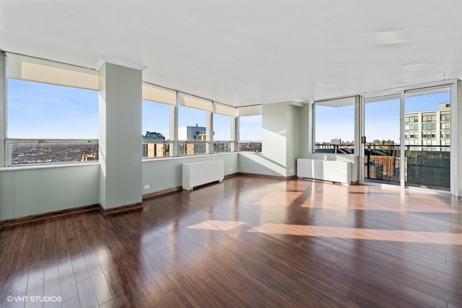 5701 North Sheridan Road, Unit 19B Chicago, IL 60660 - Photo 2 of 17 a view of a living room kitchen with a stove top oven and wooden floor