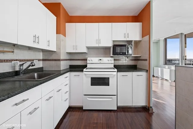 a kitchen with granite countertop white cabinets and white appliances