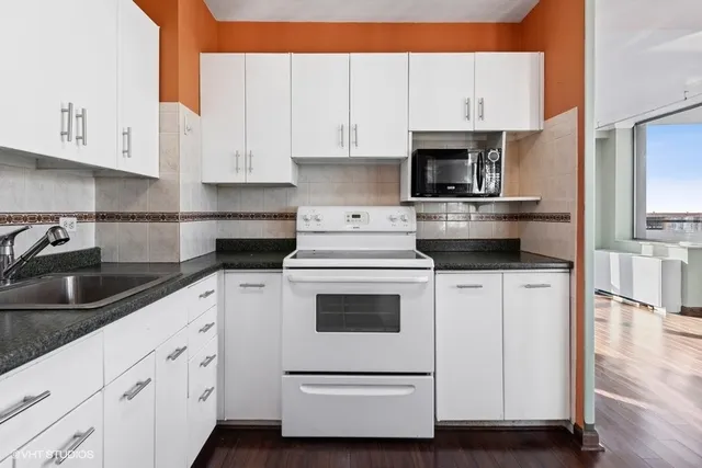 a kitchen with white cabinets and white appliances
