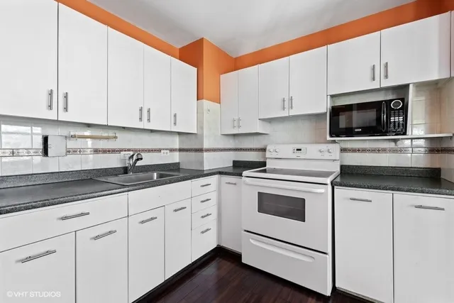 a kitchen with cabinets stainless steel appliances and sink