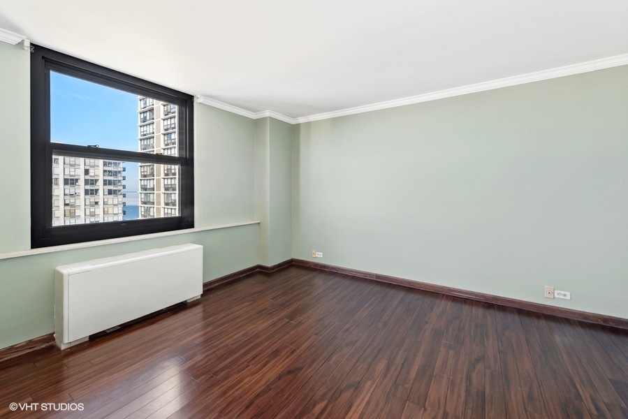 5701 North Sheridan Road, Unit 19B Chicago, IL 60660 - Photo 8 of 17 an empty room with wooden floor and windows