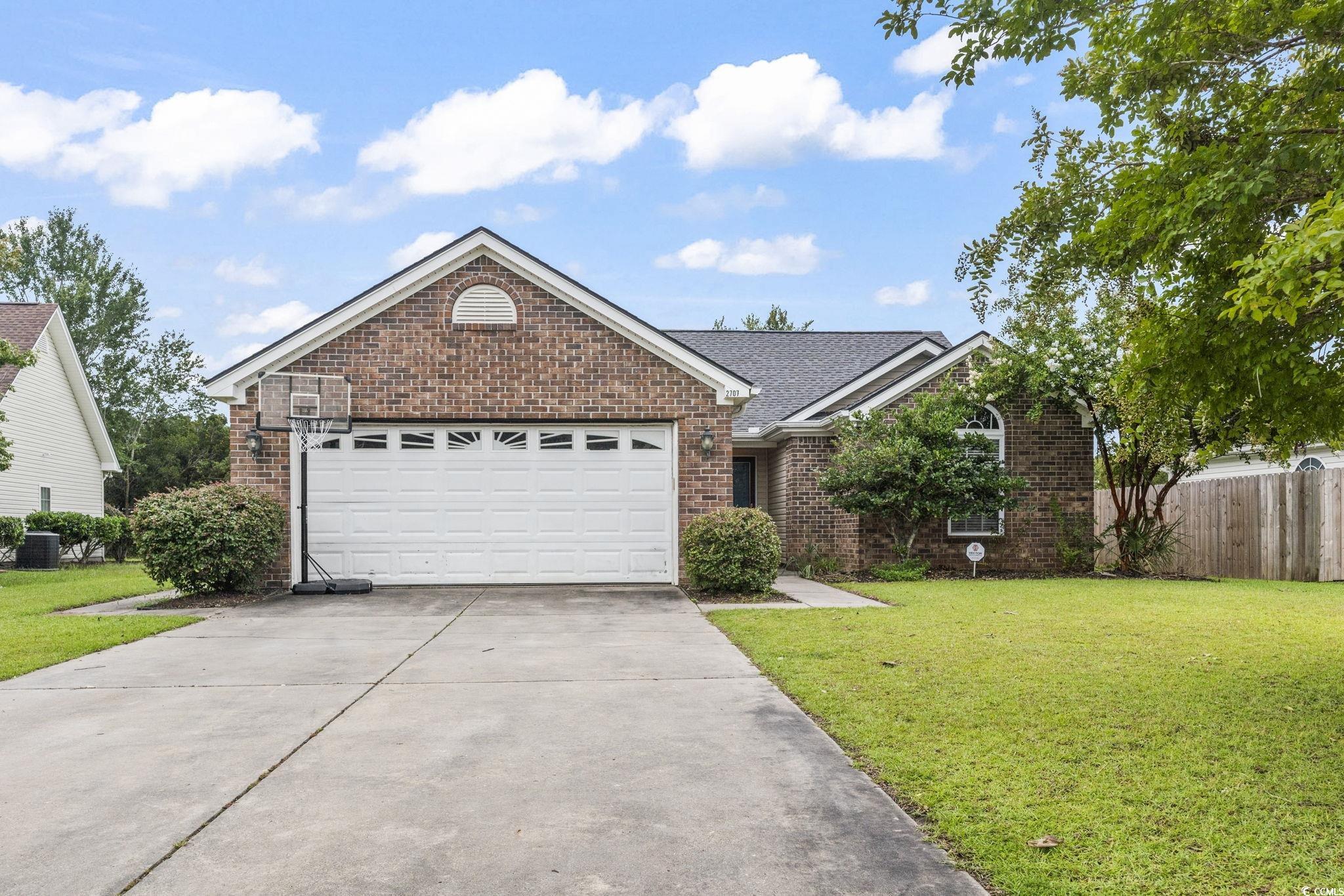 Ranch-style house featuring brick siding, driveway, and an attached garage