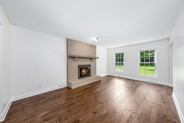 2010 Bilter Road Aurora, IL 60502 - Photo 11 of 47 an empty room with wooden floor fireplace and windows