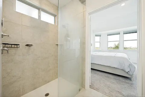 a bathroom with a tub a window and a shower