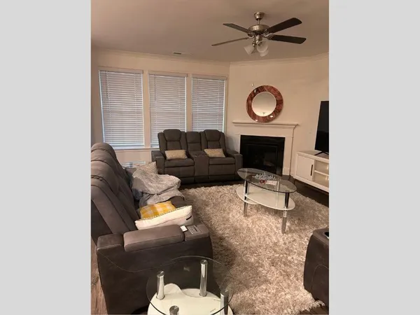 a living room with furniture a fireplace and a large window
