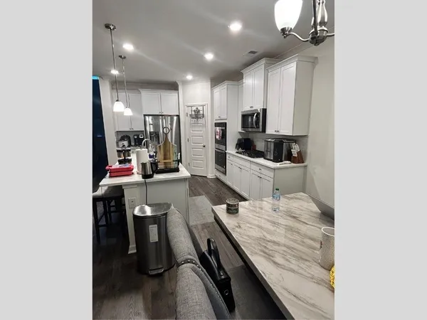 a kitchen with kitchen island a stove and a refrigerator