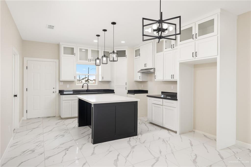 348 Coro Street Donna, TX 78537 - Photo 4 of 17 a kitchen with white cabinets and appliances